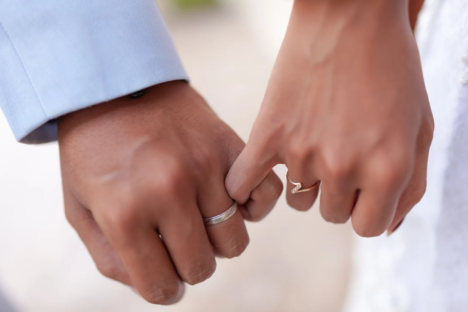 A couple linking hands, wearing their wedding rings